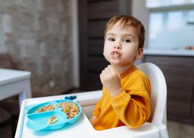 söt unge livsstil har lunch. små pojke äter porträtt. foto