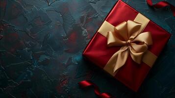 mörk röd gåva låda med elegant guld band på mörk bakgrund. hälsning gåva med kopia Plats för jul närvarande, Semester eller födelsedag foto