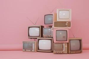 årgång tv uppsättningar staplade mot en rosa bakgrund med antenner foto