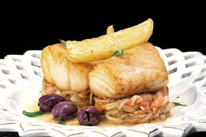 bakad torsk med lök, franska frites och oliver foto