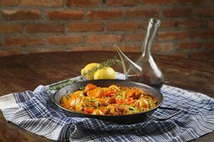 paella valenciana med skaldjur, kanin kött, kyckling, ris och saffran foto