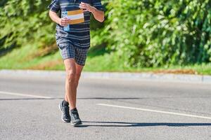 atletisk man joggning i sportkläder på stad väg foto