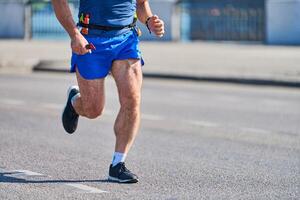 atletisk man joggning i sportkläder på stad väg foto