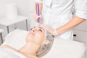 kosmetolog gör mesoterapi injektion för föryngring kvinna ansikte, procedur i skönhet salong foto