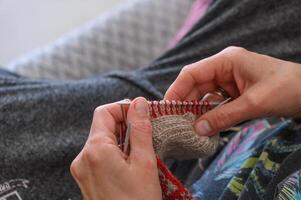 kvinnas händer sticka en strumpa med stickning nålar. närbild 2 foto