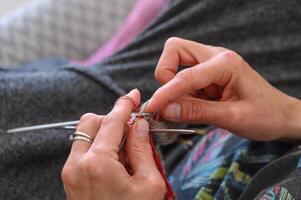 kvinnas händer sticka en strumpa med stickning nålar. närbild 1 foto