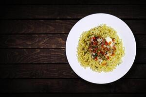 topp se av omedelbar spaghetti i vit skål med Lagt till vitlök och chili på mörk trä- bakgrund. foto
