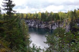 båtar flytande på de sjö i de marmor kanjon omgiven förbi höst skog foto