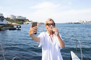 ung kvinna dricka champagne på en Yacht i de öppen hav foto