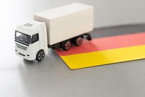 mini leksak på tabell med suddig bakgrund. industriell frakt begrepp. leksak lastbil, Tyskland flagga foto