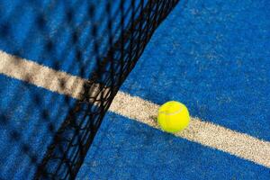 tre paddla tennis boll nära de netto, racket sporter foto