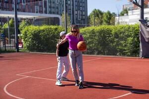 begrepp av sporter, hobbies och friska livsstil. ung människor spelar basketboll på lekplats utomhus foto