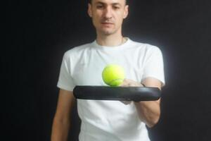 padel tennis spelare med racket i hand. paddla tennis, på en svart bakgrund. foto