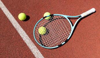 racket med en tennis boll på en röd lera domstol. foto