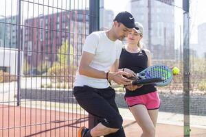 ukraina Kiev, april 02 2024. ung kvinna och man talande till varje Övrig efter spelar padel, gående längs de netto tillsammans foto