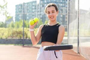 Tonårs flicka innehav padel racketen i hand och redo till lämna tillbaka boll medan spelar i domstol. foto