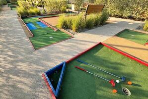 färgrik golf putters med golf bollar på syntetisk gräs foto