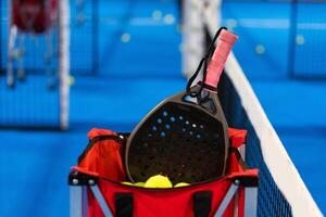 paddla tennis racket och bollar på de blå paddla domstol foto