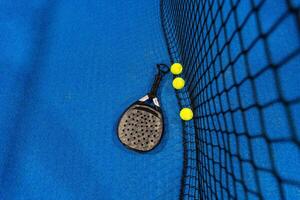 paddla tennis racket och bollar på de blå paddla domstol foto