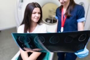 ung läkare ser på beräknad tomografi röntgen bild foto