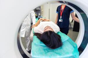 radiolog med en kvinna patient i de rum av beräknad tomografi. foto