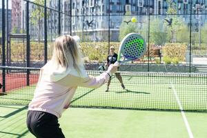 ukraina Kiev, april 20 2024. porträtt av leende kvinna paddla tennis spelare under par match på domstol foto