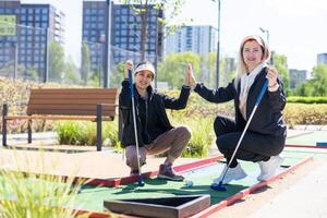 mor och dotter spelar mini golf, barn njuter sommar semester foto