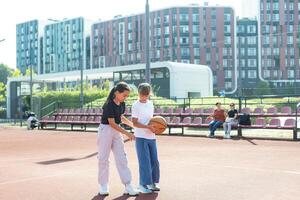 begrepp av sporter, hobbies och friska livsstil. ung människor spelar basketboll på lekplats utomhus foto