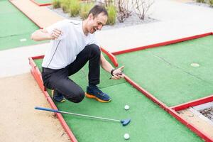 spelare utseende på hans träffa på en mini golf kurs foto