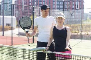 sporter par med padel racketar Framställ på tennis domstol foto