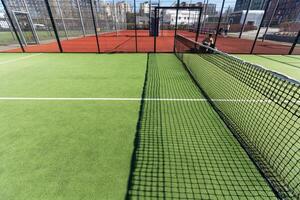 anlagd områden av en bostads- utveckling med en tennis domstol med hög plexiglas och metall staket foto