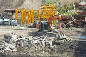 antenn se hydraulisk sax på tackling till skära övergiven byggnader förstöra byggnad, hydraulisk sax på rigg av kran skära byggnad på konstruktion webbplats. foto