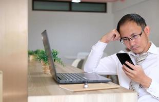 ung affärsman som använder en bärbar dator vid sitt skrivbord i ett modernt kontor
