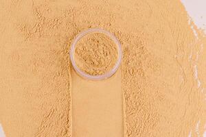 en kosmetisk burk med lösa pulver i en beige tona står på de prov med en spår av en burk och en bakgrund av lösa pulver. dekorativ kosmetika foto