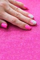 skön kvinna händer med manikyr på en rosa skinande bakgrund. tonade nagel design. sommar manikyr. kopia Plats. foto