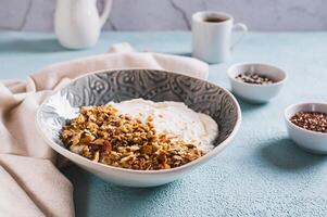 skål med yoghurt, mysli och nötter för en friska frukost på de tabell foto