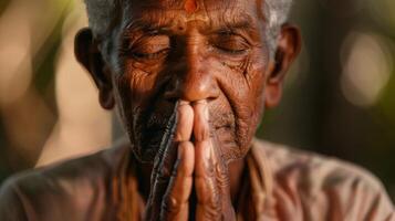 äldre man med vikta händer bön, ögon stängd i gest av vördnad foto