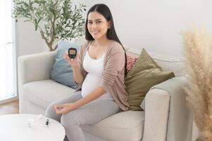 gravid kvinna kontroll blod socker nivå förbi använder sig av digital glukos meter, hälsa vård, medicin, diabetes, glykemi begrepp foto