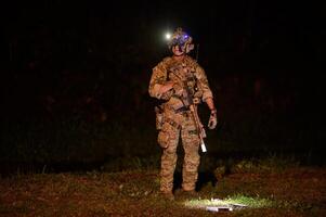 soldater i kamouflage uniformer siktar med deras gevär redo till brand under militär drift på natt soldater Träning i en militär drift foto