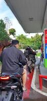 lång kö av motorcykel drivrutiner offentlig tankning på pertamina gas station. bekasi, väst java, indonesien - Maj 22 2024 foto