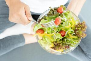 diet och bantning, njut av äta. friska kvinna håll sallad mat och känsla Lycklig. skönhet smal kvinna kropp uppnår vikt förlust mål för friska liv, galen handla om tunnhet, tunn midja, nutritionist. foto