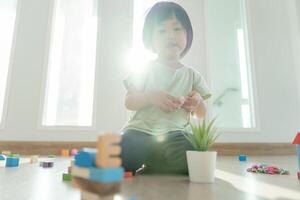 Lycklig asiatisk barn spelar och inlärning leksak block. barn är mycket Lycklig och upphetsad på Hem. barn ha en bra tid spelar, aktiviteter, utveckling, uppmärksamhet underskott hyperaktivitet oordning foto