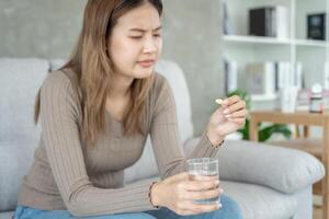 flicka innehav medicin och ta medicin, smärta, bota sjukdom, sterilisera, ta vitamin, lugnande, hälsa vård, diet- tillägg, medicin för medicinsk behandling, tonic, dagligen dosering av medicin foto