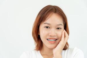 behandling. dental vård. skön asiatisk kvinna friska smile.metall konsoler på tänder. ung kvinna leende med tandställning och visa skön av tänder, vård efter tandställning, självsäker i ortodonti foto