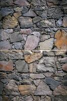 gammal vägg av sten skal sten av slumpmässig form. foto