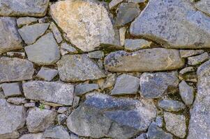 gammal vägg av sten skal sten av slumpmässig form. 4 foto