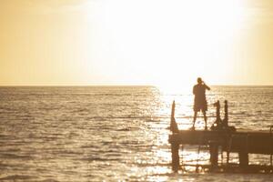 fiskare på piren vid solnedgången i bayahibe foto