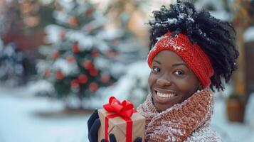 en kvinna innehav en jul gåva i främre av en jul träd foto