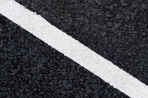 vit diagonal märkning linje på de asfalt väg som bakgrund, textur, abstrakt foto