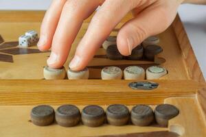 trä- backgammon styrelse med spelare hand, närbild foto